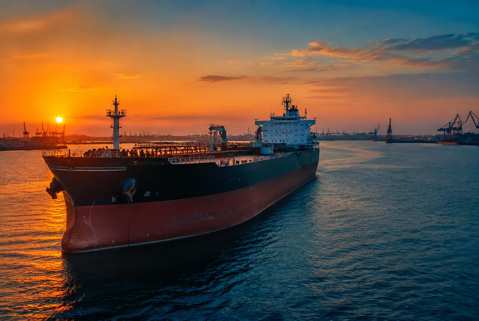 Oil tanker berthed at port during sunset